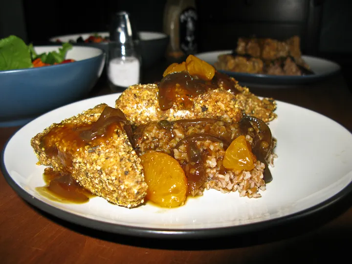 Cornmeal encrusted tempeh with orange sauce