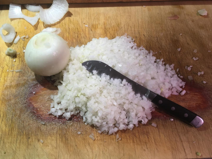 Photo of chopped onion with knife, and whole onion