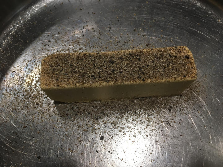 Photo of margarine covered in black pepper, sitting in a pan