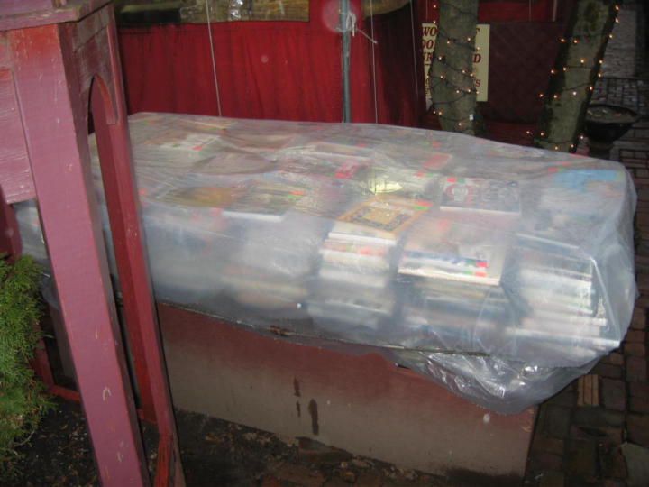 Outside, plastic-covered books await liberation.